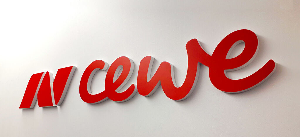 Logo rojo de CEWE en una pared blanca.