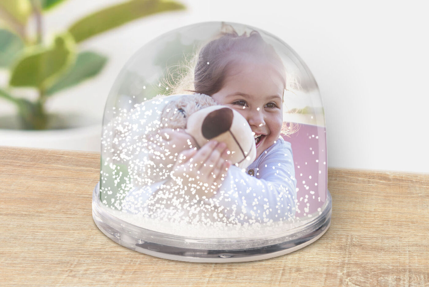 Una decoración de bola de nieve con una fotografía personal en el fondo
