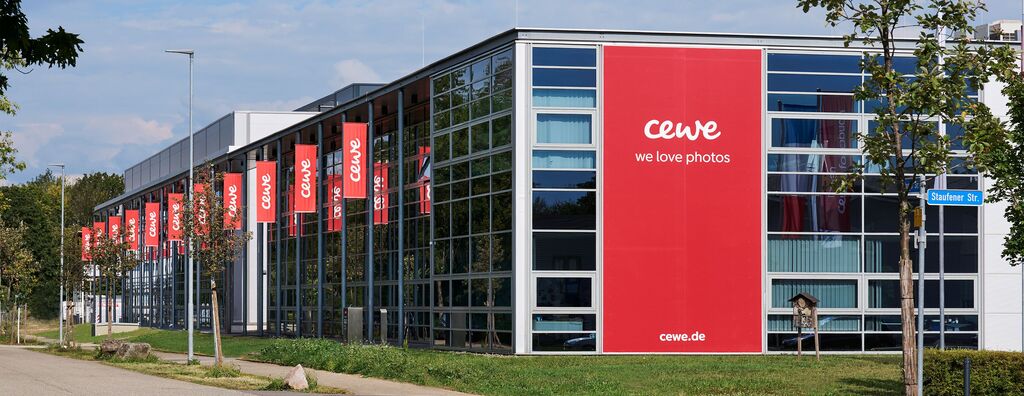 El edificio de CEWE con grandes ventanas y fachada roja.