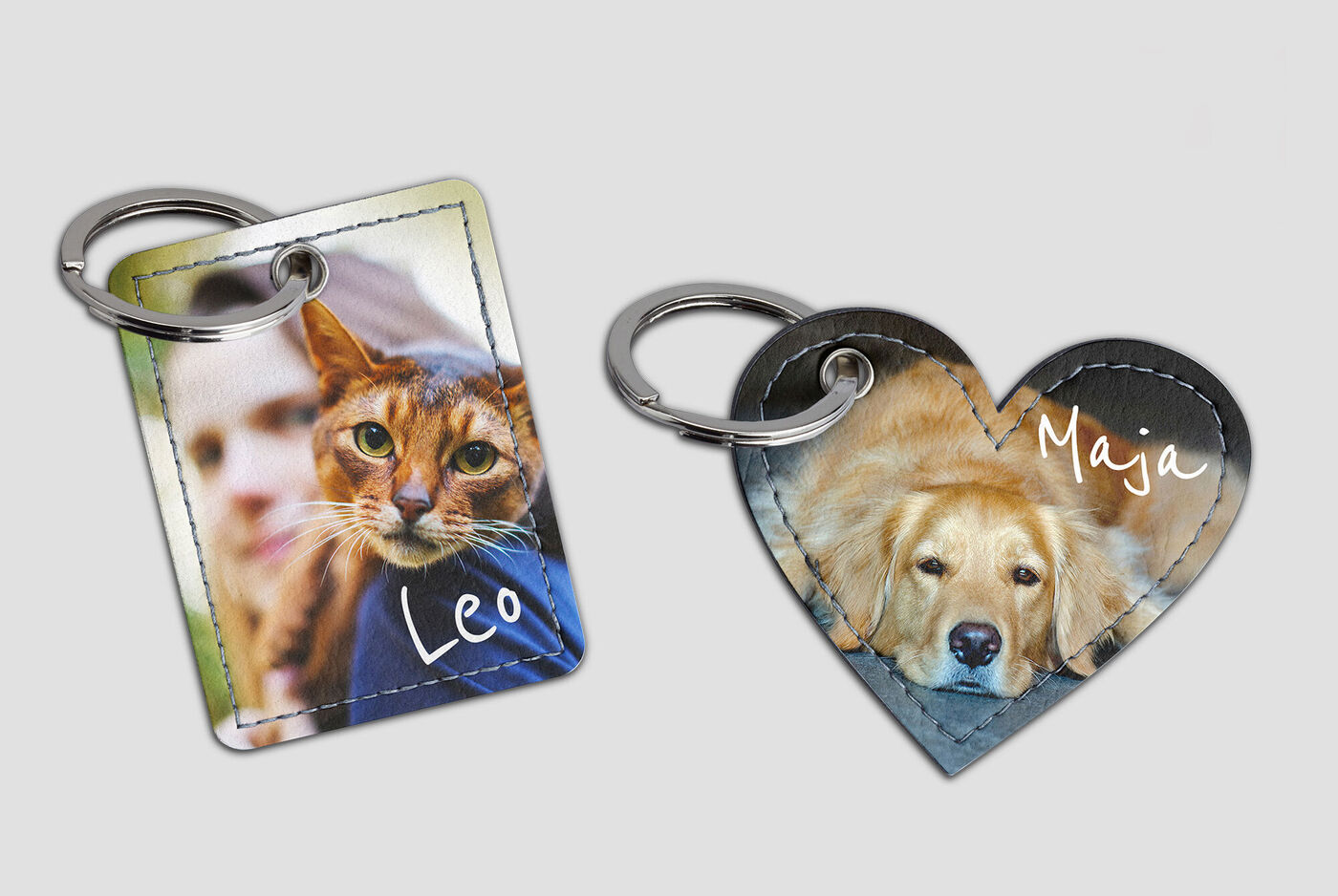 Dos llaveros personalizados, uno con la foto de un gato y nombre y el otro en forma de corazón con un perro y nombre.