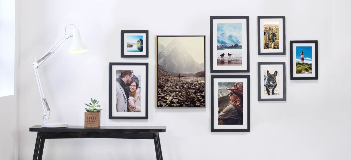 Pared con varias fotos enmarcadas y una lámpara